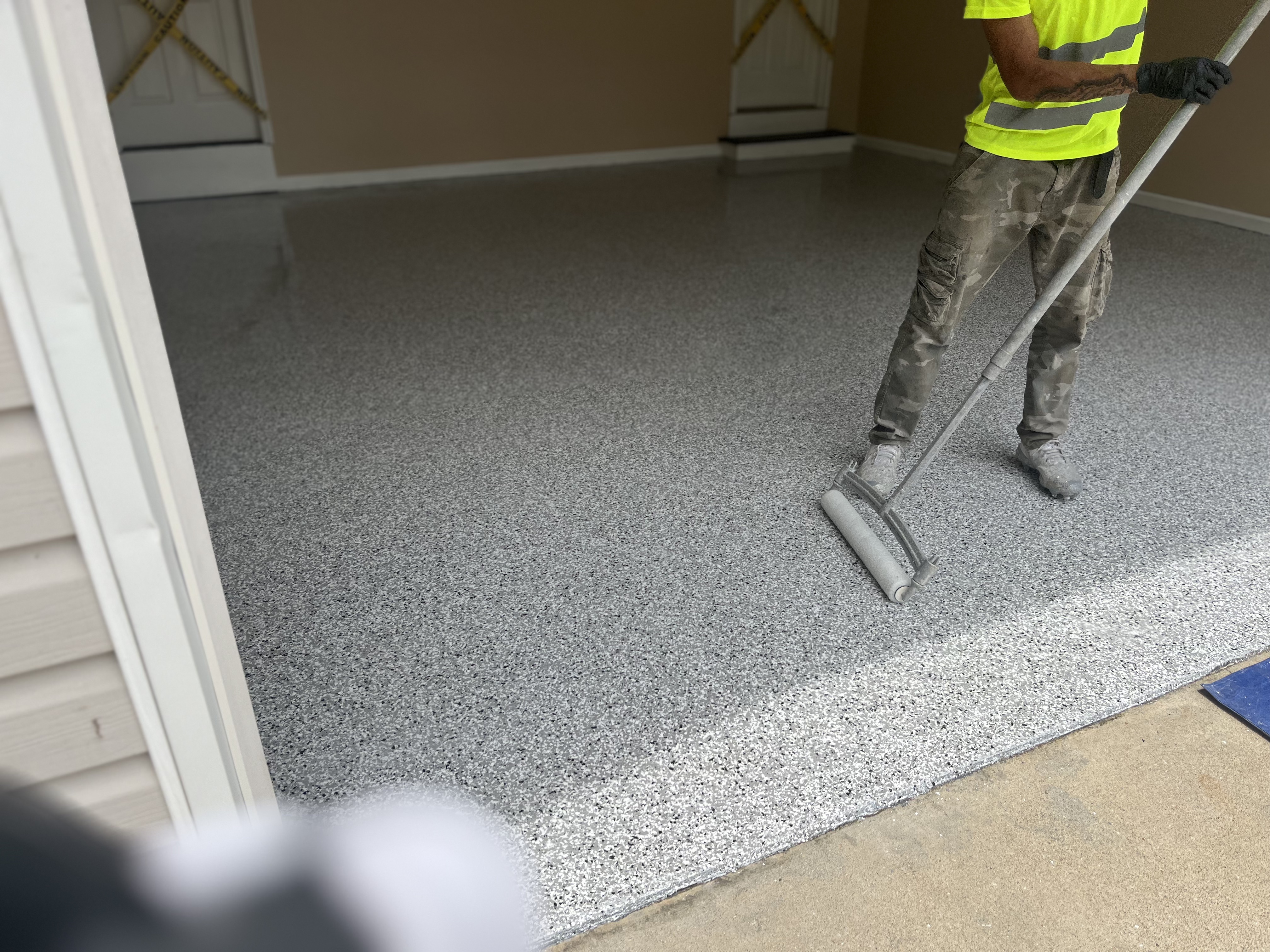 Epoxy floor installation crew rolling topcoat garage residential