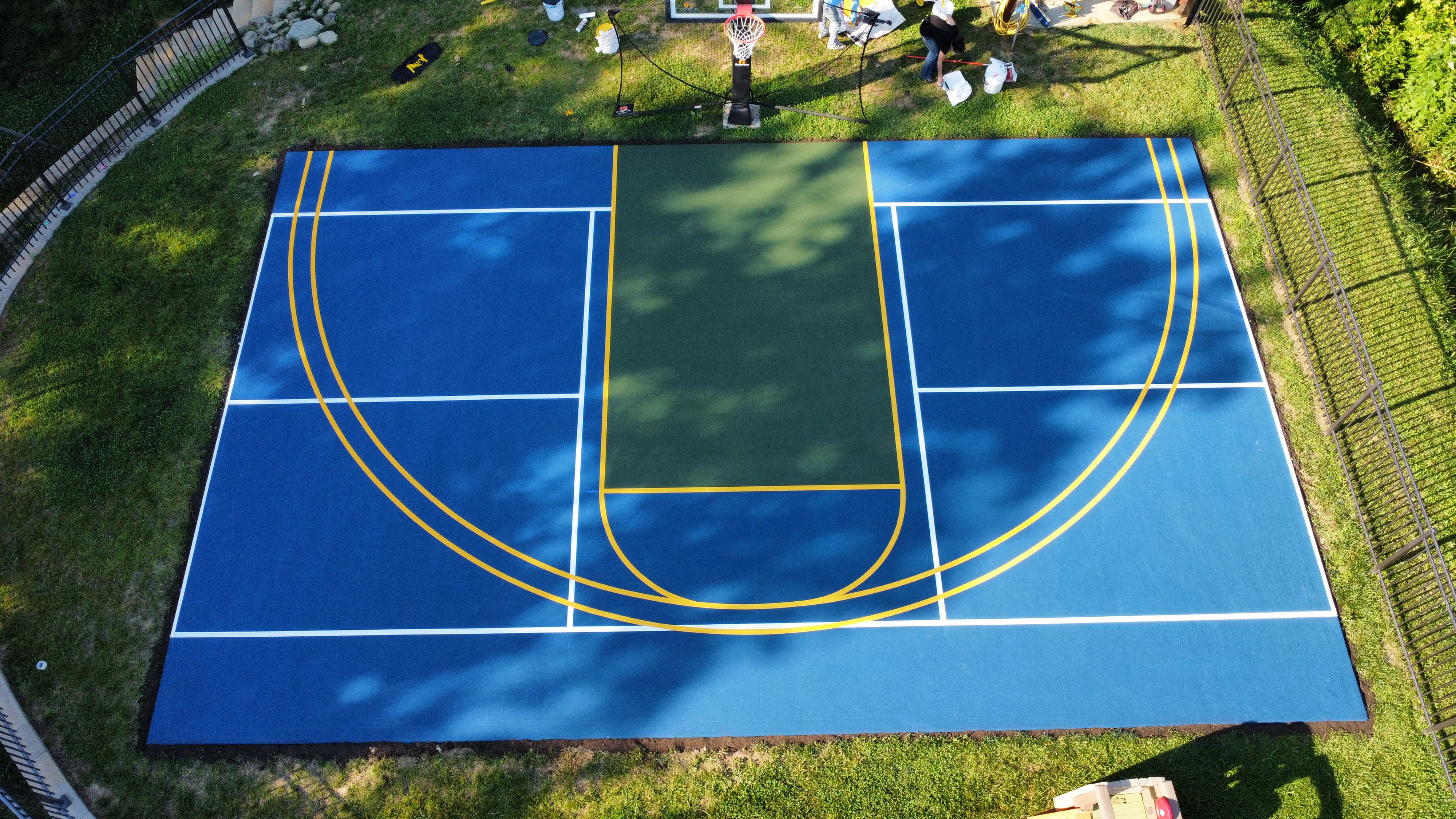 Outdoor basketball court blue gold residential aerial drone